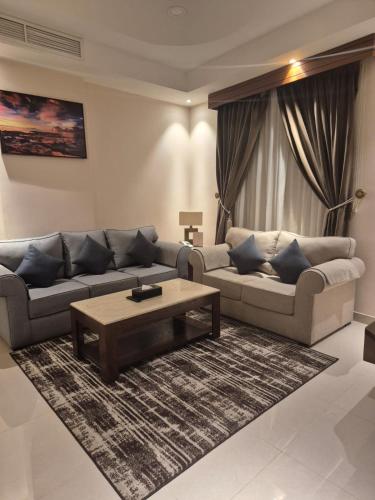 a living room with a couch and a coffee table at SAS Al Olaya Hotel Aprtments in Al Khobar
