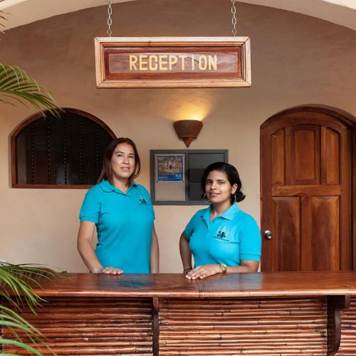 two women standing in front of a reception desk at Boutique Hotel Secret Garden Granada in Granada