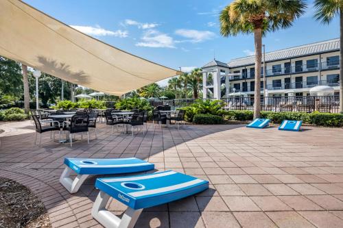 a patio with tables and chairs and a large umbrella at voco Kissimmee Orlando by IHG in Orlando