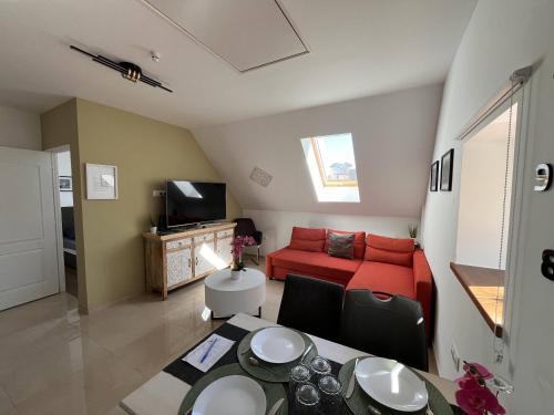 a living room with a red couch and a table at Kossuth Apartmanház in Tata