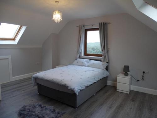 a bedroom with a large bed with a window at Forrest view in Dunfanaghy