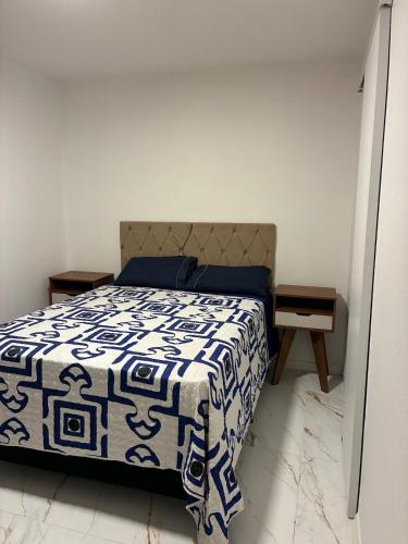 a bedroom with a bed with a blue and white blanket at Apartamento albion in Porto Alegre