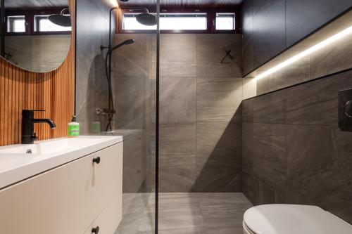 a bathroom with a shower and a toilet and a sink at Moderni puuhuvila erämaan reunalla Kiilopäällä in Saariselka