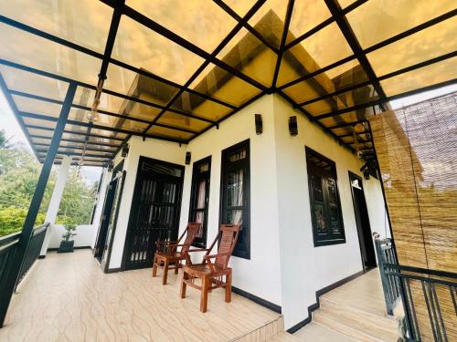 a house with a porch with chairs on it at Meadow View Villa in Dickwella