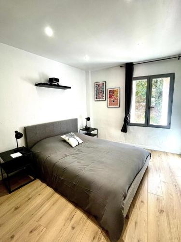 Un dormitorio con una cama grande y una ventana. en Superbe T2 meublé - Style Jungle - Draguignan, en Draguignan