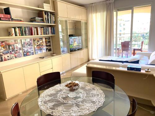 a living room with a glass table and a bed at Monaco, elegant & quiet renovated apartment, with terrace & pool, 15min walk to Port Hercule in Monte Carlo