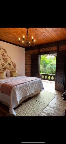 a bedroom with a large bed and a chandelier at Pousada Pedra Azul in Pedra Azul