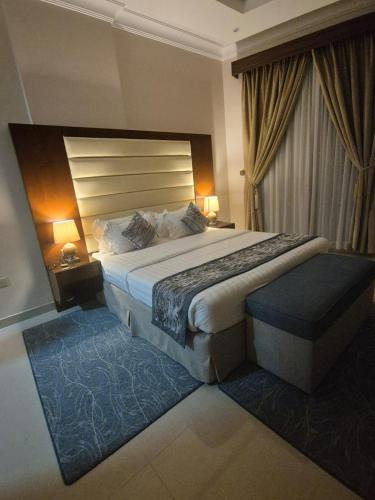 a hotel room with a large bed and two lamps at SAS Al Olaya Hotel Aprtments in Al Khobar