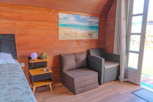 a bedroom with a bed and a chair and a table at Oceana Suites Aracaju in Aracaju
