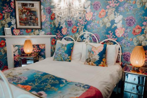a bedroom with a bed with floral wallpaper at Woodhill Country House in Otterburn