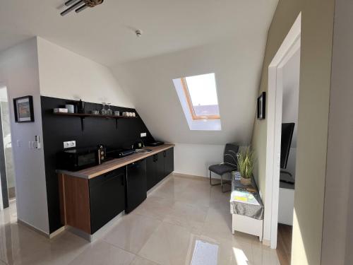a kitchen with black cabinets and a counter top at Kossuth Apartmanház in Tata