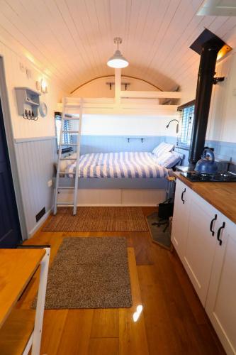 a small room with a bunk bed in a kitchen at Spring Grounds Farm Shepherd Huts in Mollington