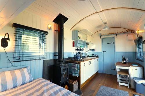 a kitchen with a stove in a room at Badger's Den Shepherd's Hut in Mollington