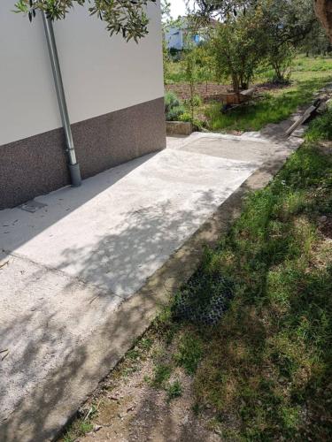 a sidewalk next to a building with a pole at Pupi Studio Apartment Trogir in Trogir