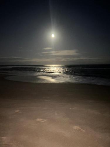 a full moon rising over the ocean at the beach at Bioflora Residence Itacimirim in Camacari