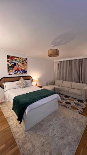 a bedroom with a bed and a couch at Spacious and comfortable Central London Room, near Victoria in London