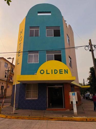 a blue and yellow building with a sign on it at HOTEL OLIDEN in Coatzacoalcos