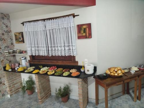 een tafel met veel verschillende soorten voedsel erop bij Pousada Holú in Itaúnas