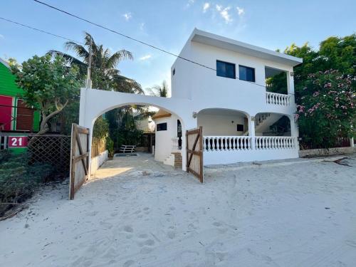 a white house with an archway in the sand at Casa Je'elel Chuburna Puerto in Chuburná