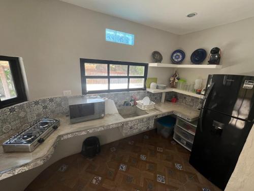 a kitchen with a counter top with a refrigerator at Casa Je'elel Chuburna Puerto in Chuburná