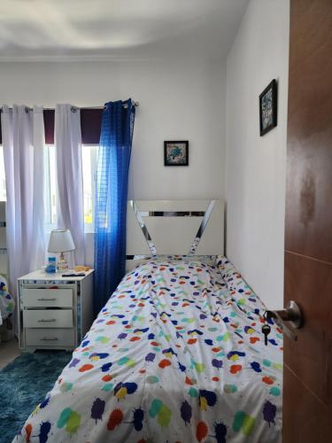 a bedroom with a bed and a desk and a window at Sun and sand in Boca Chica