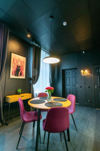 a dining room with a table and pink chairs at Apartments24 Black 1903 in Rakvere