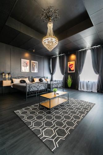 a living room with a couch and a chandelier at Apartments24 Black 1903 in Rakvere