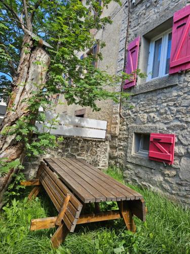a wooden bench sitting in front of a building at Maison de montagne in La Llagonne