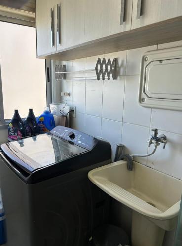 a bathroom with a sink and a toilet and a sink at Cozy Place Curitiba in Curitiba
