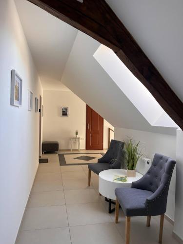 a living room with two chairs and a table at Kossuth Apartmanház in Tata