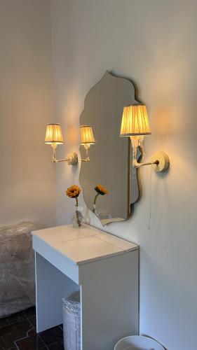 a dressing table with two lamps and a mirror at THHPSOCIETY - Kahaani boutique Stays - Vagator Goa in Anjuna
