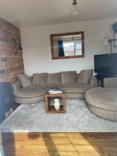 a living room with a couch and a table at Affordable Single Room in Saltney