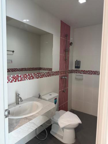 a bathroom with a sink and a toilet and a mirror at Jellyfish Residence in Patong Beach
