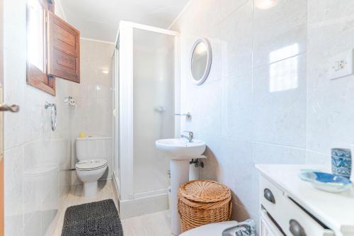 a white bathroom with a toilet and a sink at RentitSpain Casa Estrella del Mar, a 400 metros de la playa in Castell de Ferro