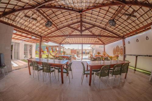 a dining room with wooden tables and chairs at Oceana Suites Aracaju in Aracaju