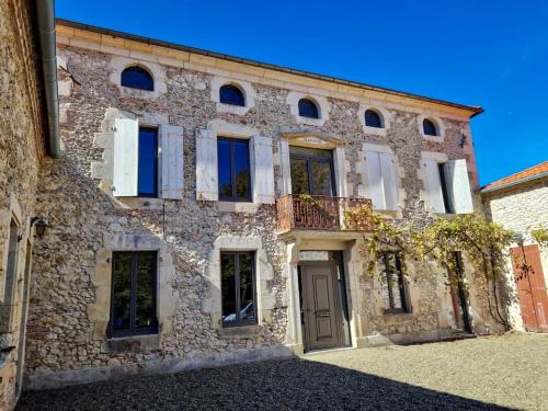 an old stone building with a door and windows at DOMAINE De PLAISANCE in Cachen