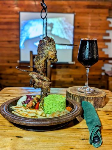 a plate of food and a glass of wine on a table at La Maison de Canelya in Cotonou