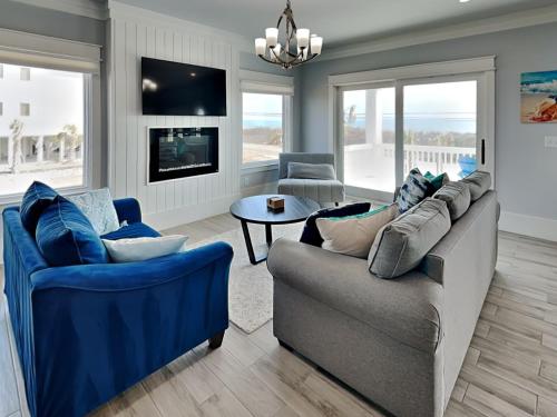 a living room with two couches and a tv at Dune Our Thing North Topsail Beach in North Topsail Beach