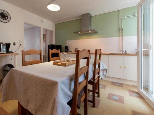 a dining room with a table and chairs and a kitchen at gîte Loré in Vertus