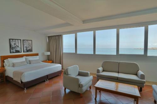 a bedroom with a bed and a couch and a chair at Hotel Almirante Cartagena Colombia in Cartagena de Indias