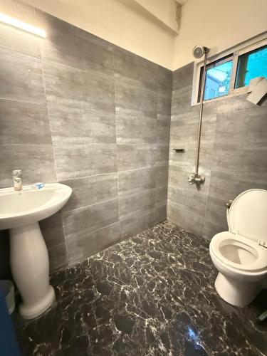 a bathroom with a toilet and a sink at Atlas Gold Hotel in Islamabad