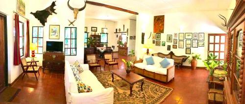 a living room with white couches and a tv at Captain's Bungalow, Kandy in Arawwawala