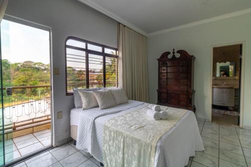 a bedroom with a bed and a balcony at Recanto dos Passaros - Wifi Garagem Gourmet in Goiânia