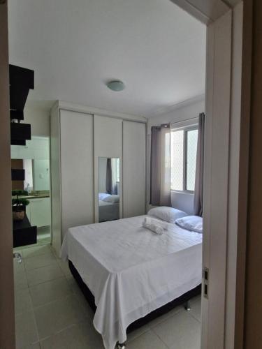 a bedroom with a white bed and a window at Edificio Versatto Residence in Belém
