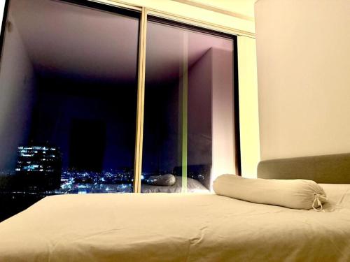 una cama en una habitación con una ventana grande en LUXURY 1BD 1BTH MODERN APARTMENt, en Los Ángeles