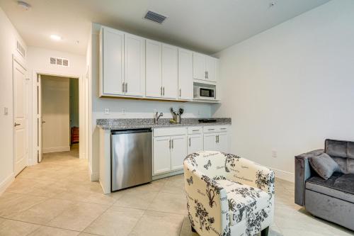 a kitchen with white cabinets and a chair in a room at Beach-Hop and Golf! Port St Lucie Apt with Shared Yard in Eden