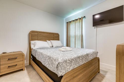 a bedroom with a bed and a tv on the wall at Beach-Hop and Golf! Port St Lucie Apt with Shared Yard in Eden