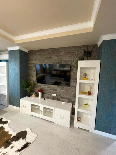 a living room with a tv and a white entertainment center at Pensiunea Crystal in Iaşi