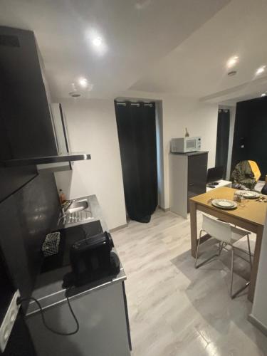 a small living room with a table and a kitchen at La bohème C.A in Dijon