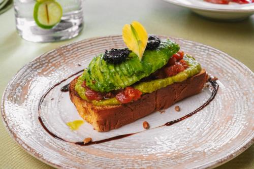 a piece of bread with a pickle on top on a plate at Hotel Sinchronas in Telšiai